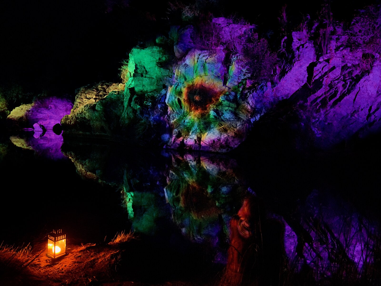 Light installation reflected in still water at Pego das Pias